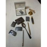 A damaged hallmarked silver cigarette case, a silver spoon, various lighters, and three pens.