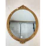 An oval gilt mirror with decorative finials to top and bottom. 70 cm h x 53cm