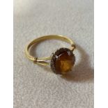 An 18ct yellow gold oval dress ring set with tiny diamonds and central orange oval stone, size V,