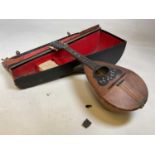 A circa 1900 Neopolitan barrel backed mandolin with mother of pearl inlay and bearing label