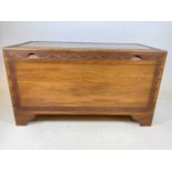 A mid century camphor wood chest with interior sliding tray and shell cup handles to the sides,