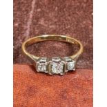 An 18ct yellow gold three stone diamond ring, size M, and a yellow metal eternity ring, size O,