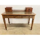 A leather topped writing desk with two main drawers on turned legs and large ceramic castors,