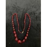 A vintage facet cut cherry amber coloured graduated necklace, length 68cm, approx 52g.