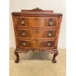 A small bowfront chest of three drawers on large ball and claw feet, with gilt moulded details and