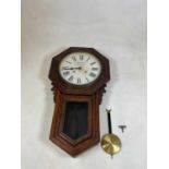 An oak wall clock with octagonal case and circular dial set with Roman numerals and inscribed '