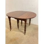 A French mahogany pull-out dining table on turned legs and castors, height 70cm, width 118 cm, depth