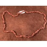 A rough cut goldstone necklace, length 84cm.