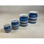 T G Green & Co Ltd; four graduated Cornishware blue and white banded storage jars, each with green