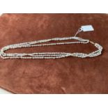 A three strand freshwater pearl necklace with 14ct yellow gold clasps and yellow metal spacers,