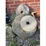 Four reconstituted stone millstone wheels, largest diameter 47cm.
