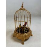 A 20th century brass bird cage automoton with red and yellow feathered birds on foliage, winding key