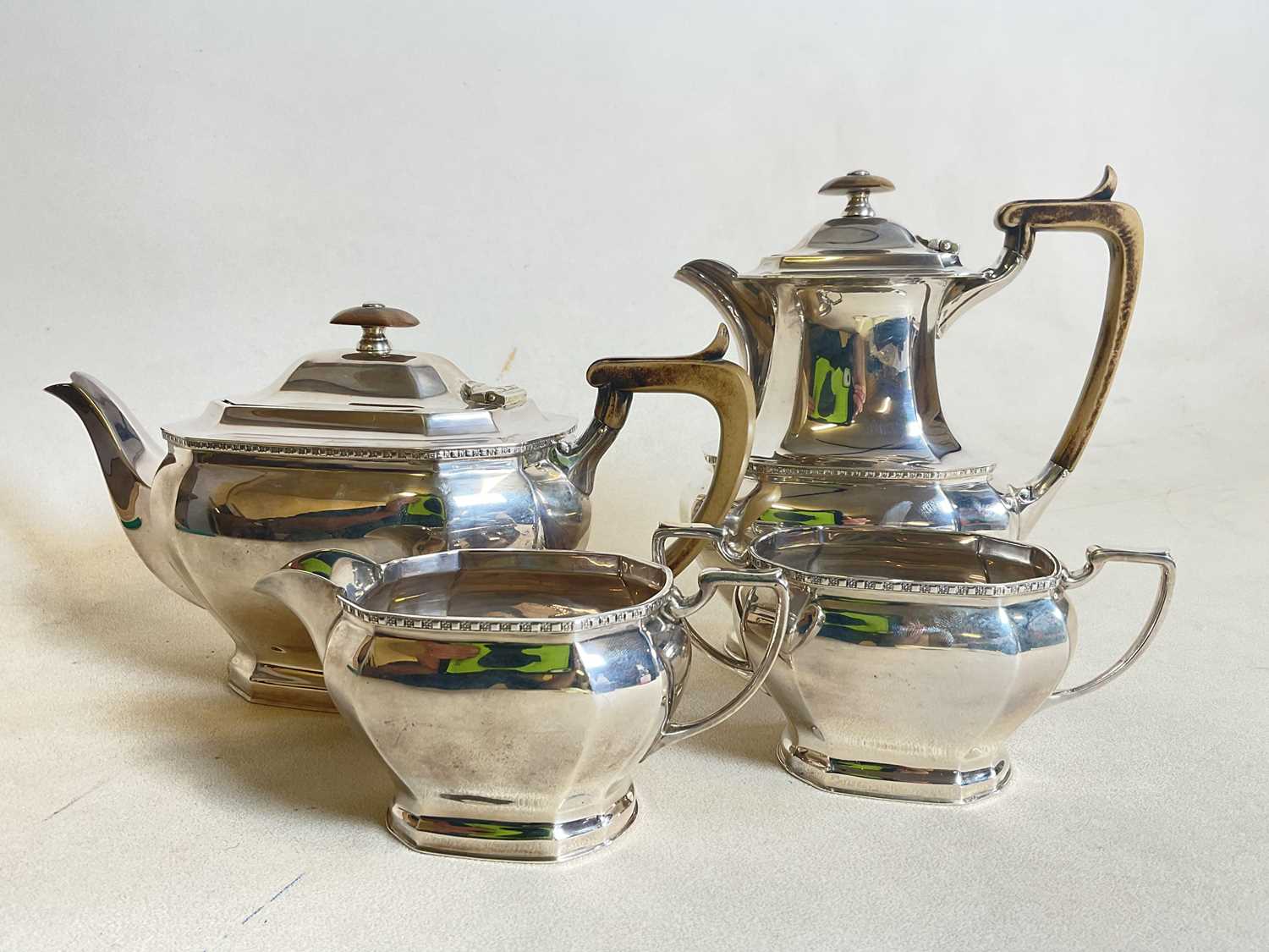 COOPER BROS AND SONS; a hallmarked silver four piece tea set comprising teapot, water jug, sugar