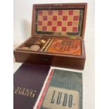 An Edwardian walnut cased games compendium featuring solitaire, chess, draaughts etc, width 33cm
