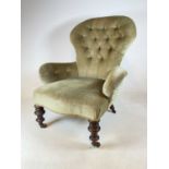 A button back nursing chair with turned legs and brass castors, seat height 34cm. (a/f, damage to