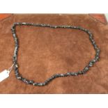 A rough cut haematite necklace, length 86cm.