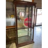 Howard Miller; a tall modern display cabinet with glazed side opening doors, top and bottom, and