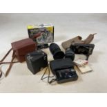 A Kodak folding camera, a cased Box Brownie, a Canon lens, etc.