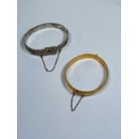 An Elizabeth II hallmarked silver bangle, Birmingham, 1973 and a gold plated bangle (2)