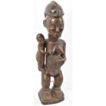 A Baule, Ivory Coast, figure holding a child with incised detail, height 58cm.Provenance: This