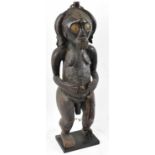 A Fang, Gabon figure, with carved coiffeur and applied with brass on contemporary display stand,