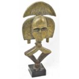 A Kota reliquary figure, Gabon, applied with brass and with iron ring, presented on a contemporary