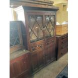 An 18th century oak cabinet with moulded cornice and carved detail, with a pair of astral glazed