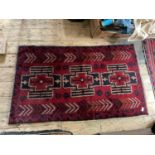 An Eastern rug with stylised decoration on a red ground, 143 x 80cm.Condition Report: Appears in