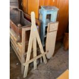 Two pairs of painted pine folding stepladders, a pine ironing board, and two easels (5)