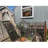 An assortment of cast metal garden gates, a cast iron column, Victorian bedframes, and assorted