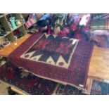 A Beluchi Afghan rug with stylised decoration on a predominantly red ground.