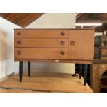 A mid century teak veneered sideboard with three drawers, with single panel cupboard door to the