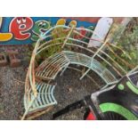 A decorative painted arch shaped garden bench.