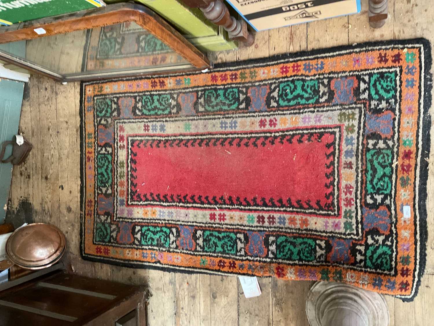A decorative rug with floral decoration in shades of orange, green, red, black and white, 156 x