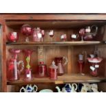 A collection of Victorian and later cranberry glass to include bells, a pair of posy vases, a pair