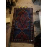 A decorative Eastern rug with stylised decoration on a predominantly blue ground, approx 150 x