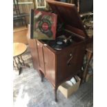 AUTOGRAPH, HARRODS, LONDON; a wind-up gramophone cabinet with two panelled doors to the front, on