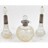 A pair of cut glass scent bottles with hallmarked silver mounts, height 18cm, and another of