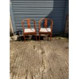 A pair of modern Chinese hardwood hoop back elbow chairs.