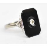 An 18ct white gold ring set with black hardstone and central white stone, size I/J, approx 4.1g.