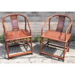 A pair of Chinese hardwood open arm elbow chairs.