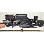 A group of cameras and camera equipment including Olympus and Canon.