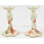 LIMOGE; a pair of candlesticks with hand painted decoration of poppies, height 16.5cm.