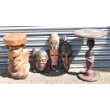 Three African style carved masks, a African style carved table and stool (5).