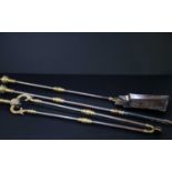 A 19th century three piece companion set, with brass finials and terminals and steel columns, length