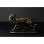 AFTER CHARLES VALTON; a bronze sculpture of a lion on rectangular plinth base, impressed