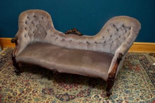 A Victorian rosewood framed settee, with central scrolling back, upholstered in a lilac material, on
