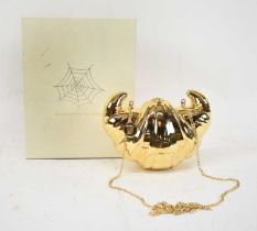 CHARLOTTE OLYMPIA; a gold plated brass croissant clutch.