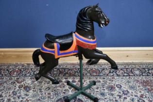 A vintage painted metal carousel horse, originally from Belle Vue Fair, now mounted on a stand,