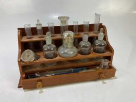 A test tube rack, together with test tubes and various glass jars, height 17cm.